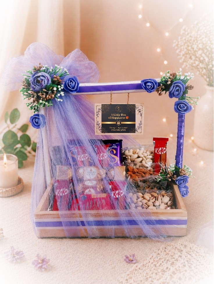 Wooden tray hamper under purple tulle with chocolate and nuts