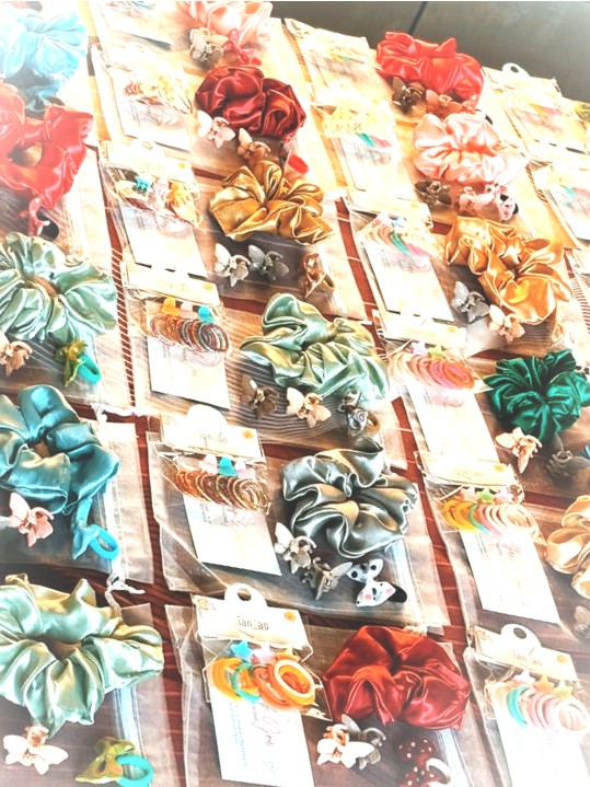 Satin scrunchies and hair clips laid out on wood