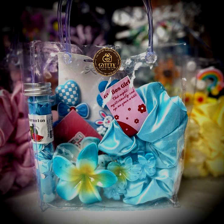 Blue clear tote hamper with scrunchies, candy and charms